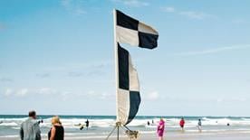 Black and white chequered beach flag Surfboard and other water craft zone or zone boundary. For surfboards, stand-up paddleboards, kayaks and other non-powered craft. Launch and recovery area for kitesurfers and windsurfers. Never swim or bodyboard here.