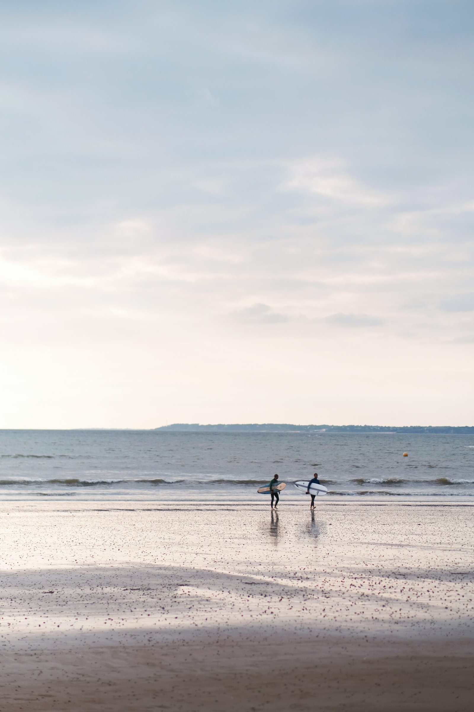 a couple of people standing on top of a beach